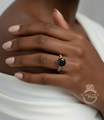 A close-up of a person's hand wearing a ring with a large black gemstone.
