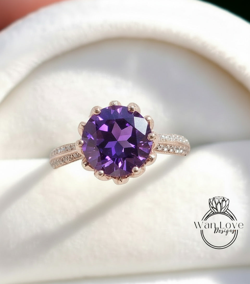 A close-up image of a gold ring with a large purple gemstone, placed on a white background.
