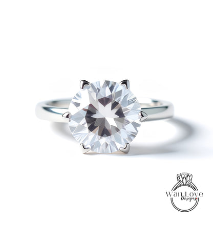 A close-up of a silver ring with a large, clear diamond set in the center.