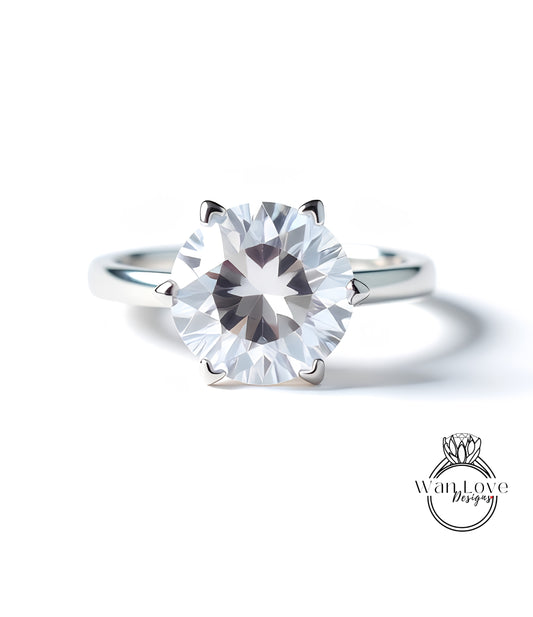 A close-up of a silver ring with a large, clear diamond set in the center.