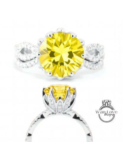 A close-up view of a yellow diamond ring with a large central diamond surrounded by smaller diamonds on either side.
