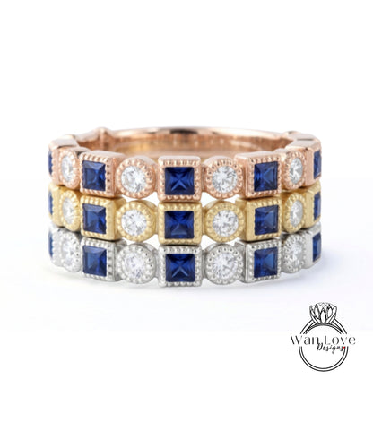 A ring with three concentric bands, each with a different type of gemstone. The top band is gold, the middle band is silver, and the bottom band is blue.