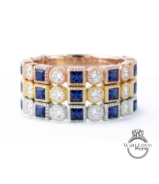 A ring with three concentric bands, each with a different type of gemstone. The top band is gold, the middle band is silver, and the bottom band is blue.