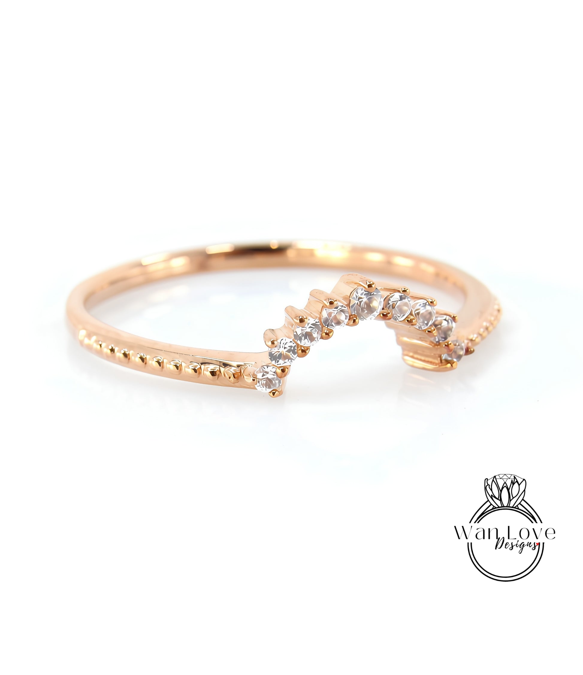 A gold ring with a diamond-encrusted band, featuring a curved design with a row of small diamonds along the band.