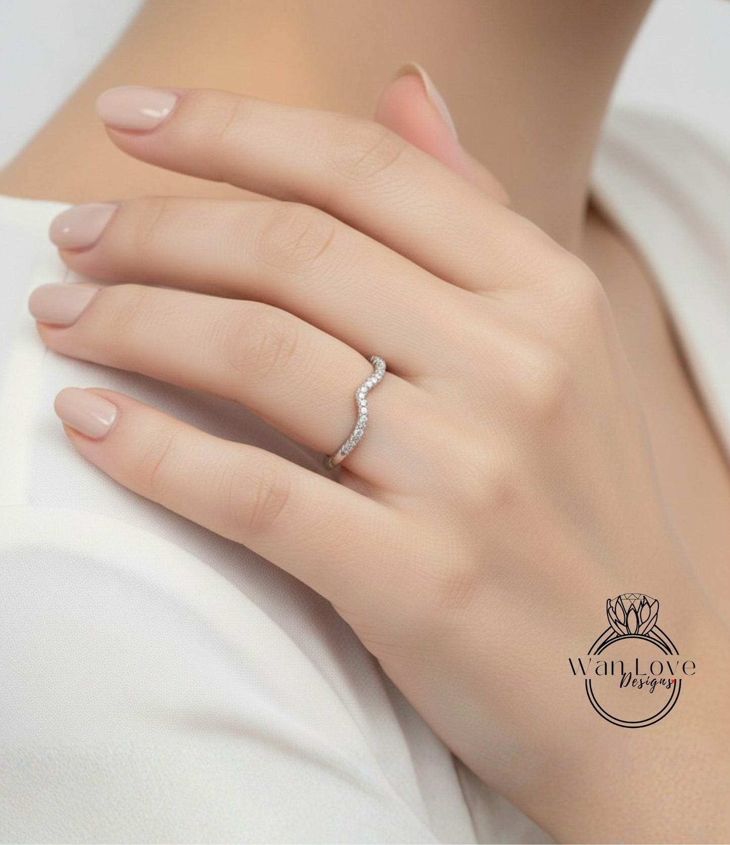 A close-up of a person's hand wearing a diamond ring on the ring finger.