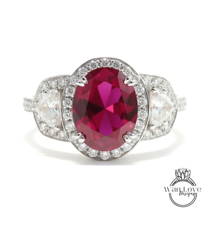 A stunning ring featuring a large oval-shaped red gemstone surrounded by a halo of smaller diamonds, set in a silver band.
