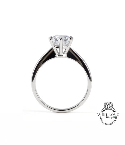 A silver engagement ring with a large central diamond and a smaller diamond on the band.