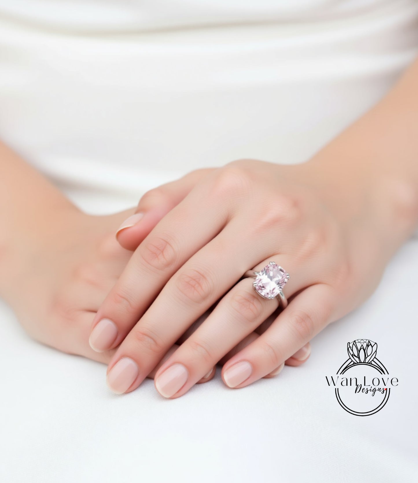 A close-up of a person's hand wearing a large, pink gemstone ring.