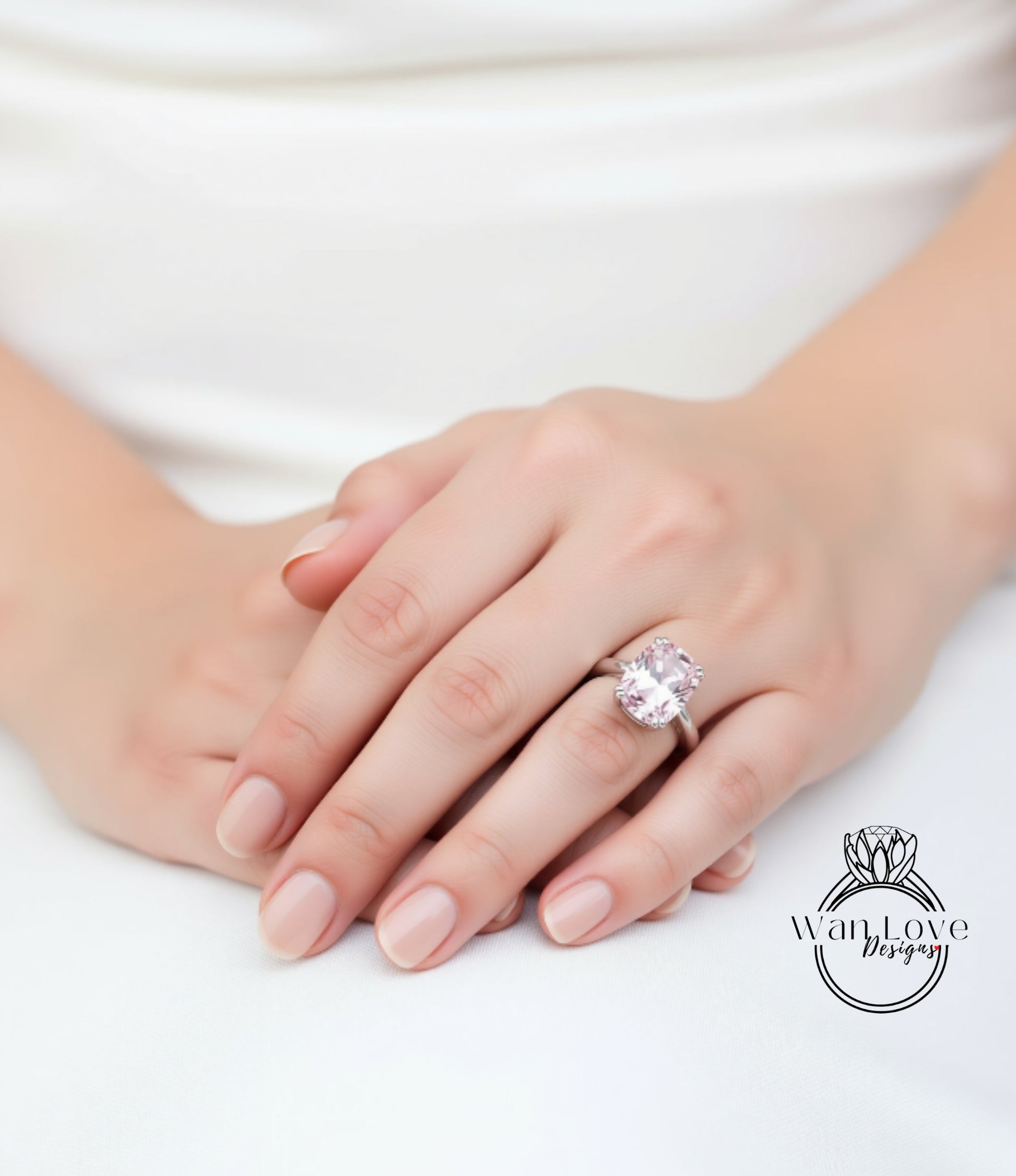 A close-up of a person's hand wearing a large, pink gemstone ring.