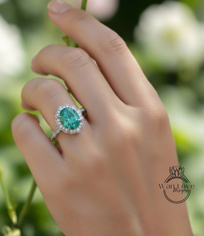 A close-up of a hand wearing a ring with a large oval-shaped gemstone, likely a diamond, set in a halo of smaller diamonds.