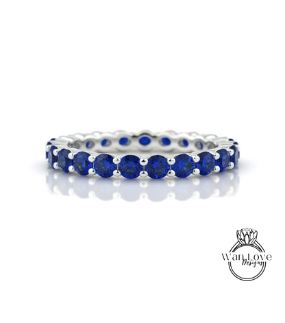 A silver band ring with a row of blue sapphire stones set in a silver band.