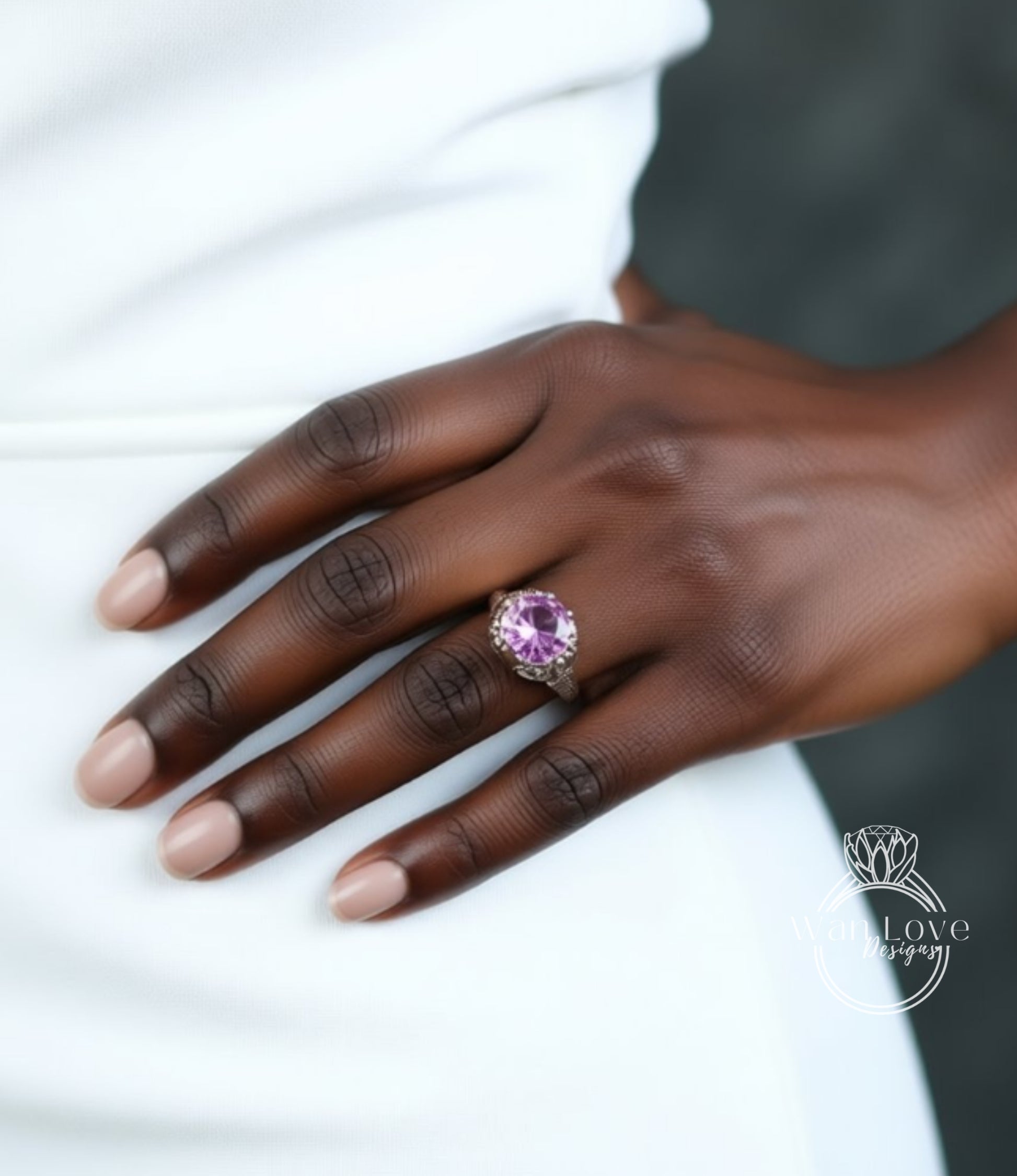 A close-up of a hand wearing a ring with a large, vibrant pink gemstone.