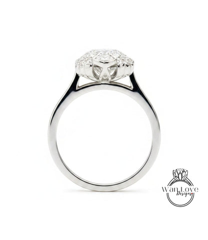 A silver engagement ring with a large central diamond surrounded by smaller diamonds.