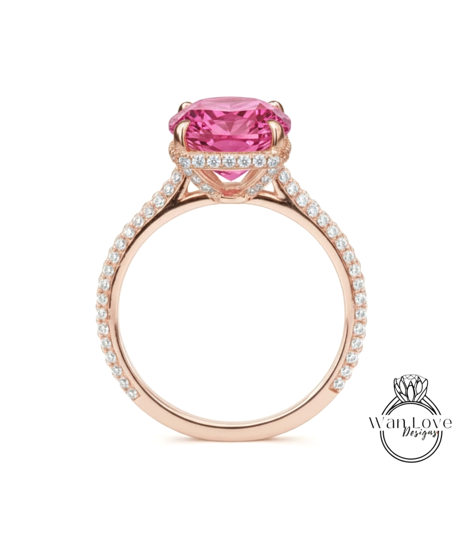 A pink gemstone engagement ring with a large central gemstone surrounded by smaller diamonds set in a rose gold band.