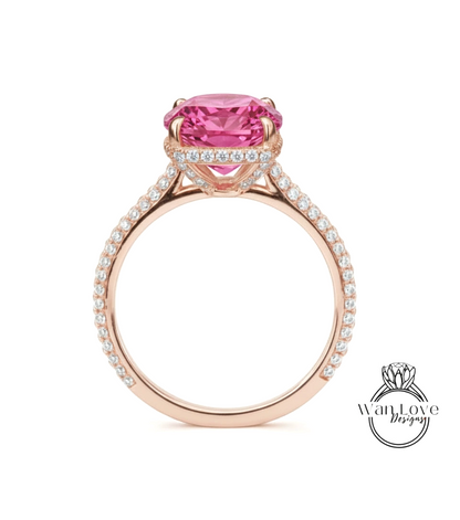 A pink gemstone engagement ring with a large central gemstone surrounded by smaller diamonds set in a rose gold band.