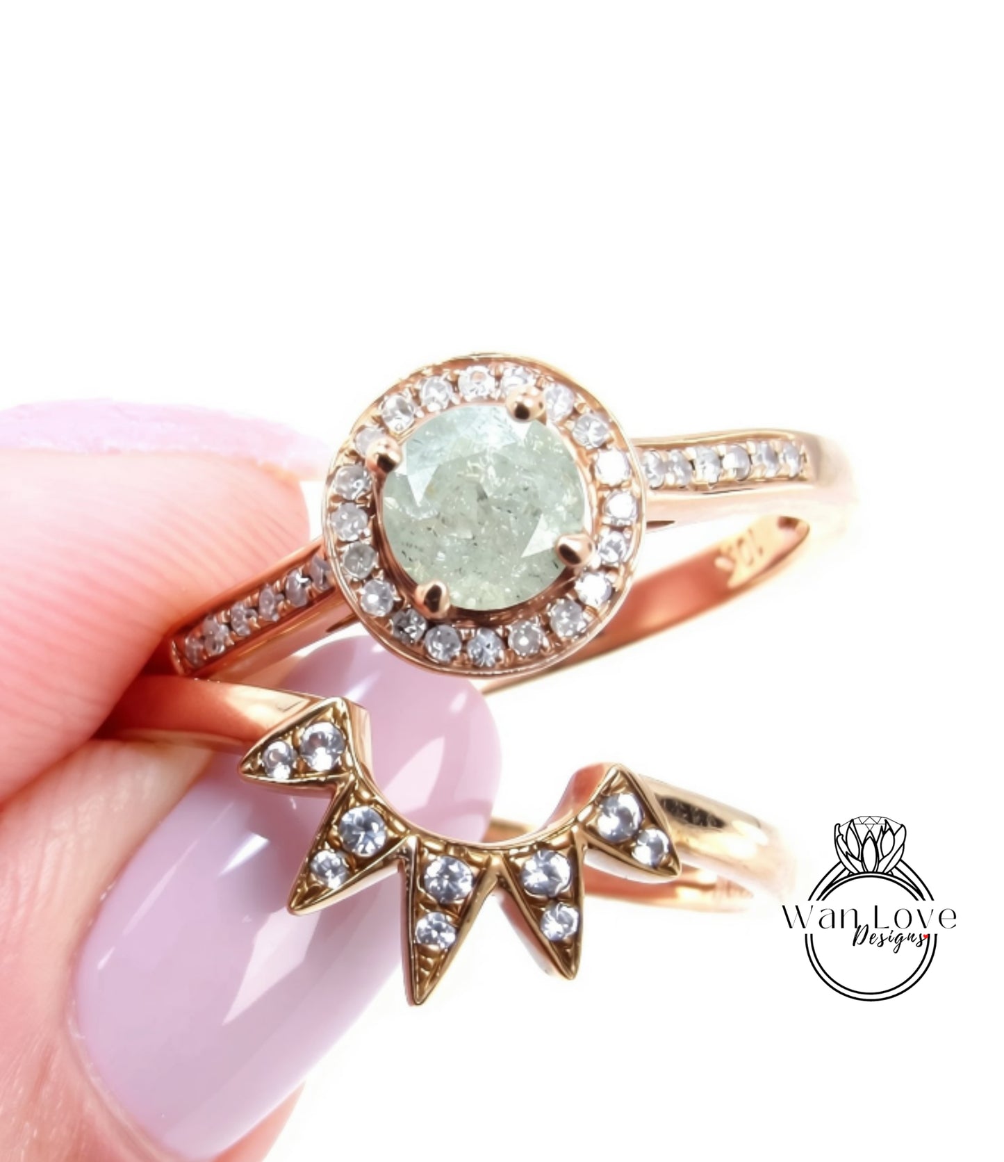 A close-up image of a person's hand holding a gold ring with a large diamond center stone surrounded by smaller diamonds, and a smaller ring with a star-shaped gemstone.