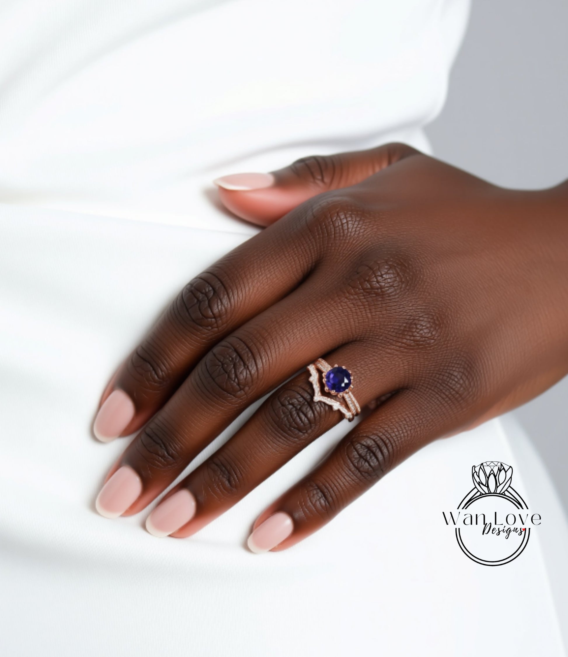 A close-up of a person's hand wearing a ring with a blue gemstone.