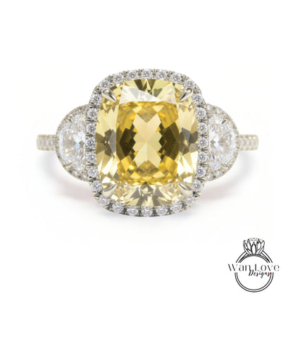 A large yellow gemstone ring with a halo of smaller diamonds around it, set in a silver band.