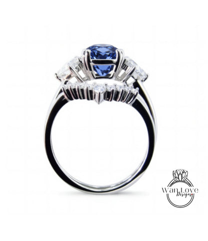 A silver ring with a large blue gemstone, likely a sapphire, surrounded by smaller diamonds.