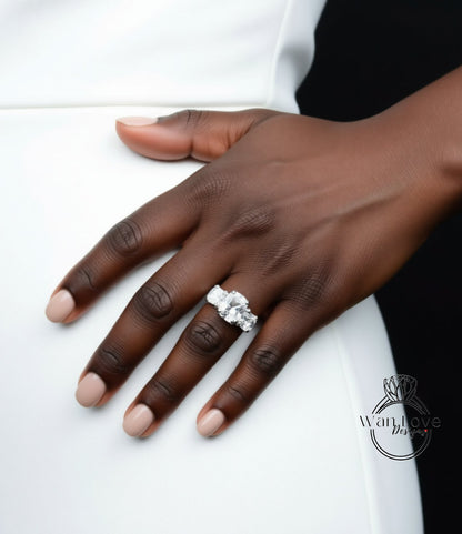 A close-up of a hand wearing a large diamond ring on the ring finger.