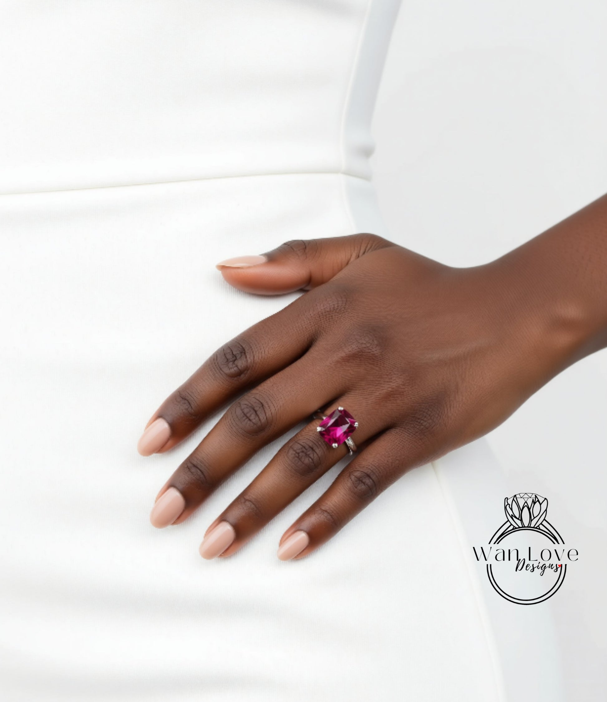 A close-up of a hand wearing a ring with a large, vibrant pink gemstone.