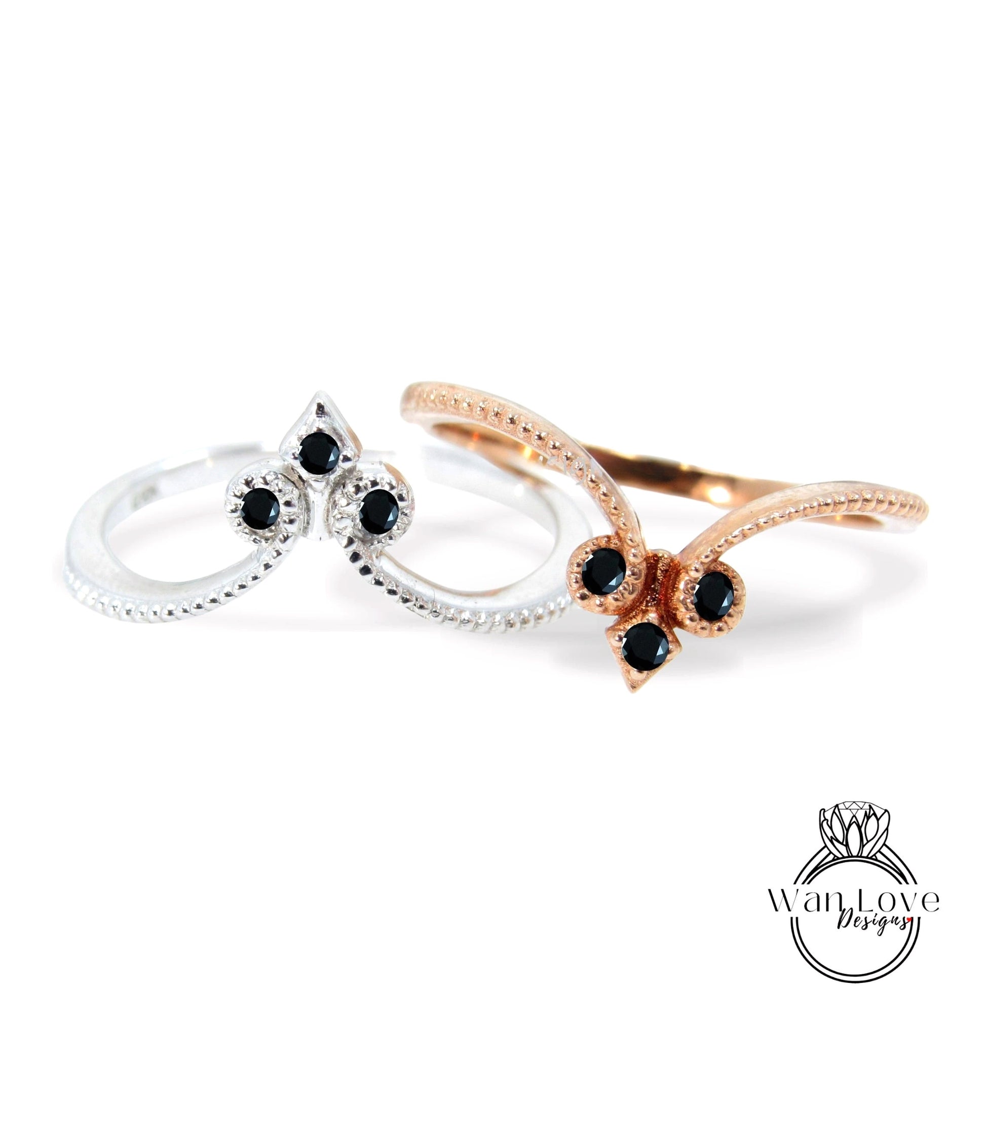 two rings with black gemstones, one silver and one gold, set against a white background.