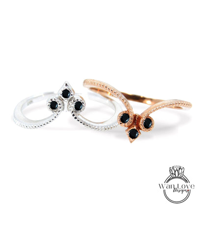 two rings with black gemstones, one silver and one gold, set against a white background.