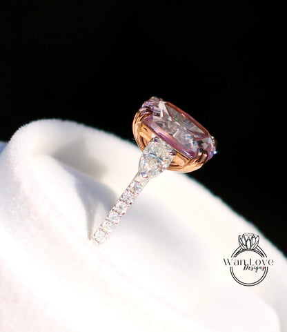 A close-up image of a diamond engagement ring with a large, round-cut pink diamond set in a gold band, placed on a white fabric surface.
