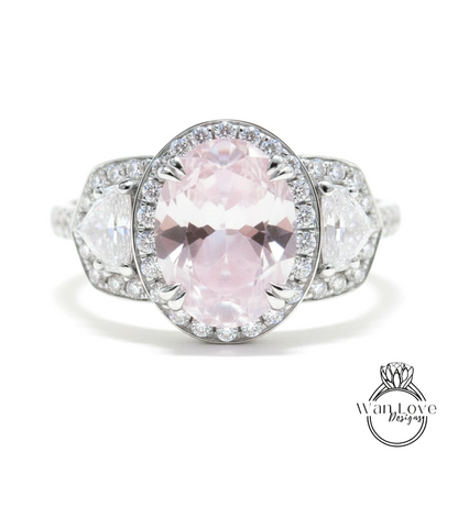 A close-up of a beautiful pink gemstone ring with a halo of smaller diamonds around it, set in a silver band.