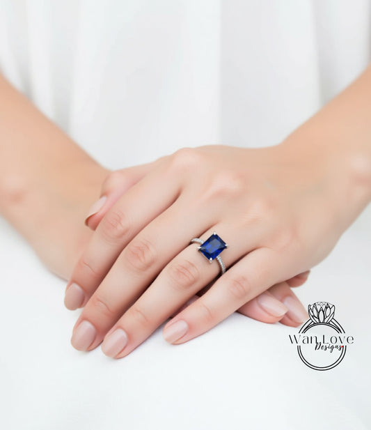 A close-up of a person's hand wearing a ring with a large blue gemstone.