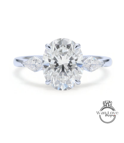 A close-up of a diamond engagement ring with a large oval-shaped diamond set in the center, surrounded by smaller diamonds on either side.