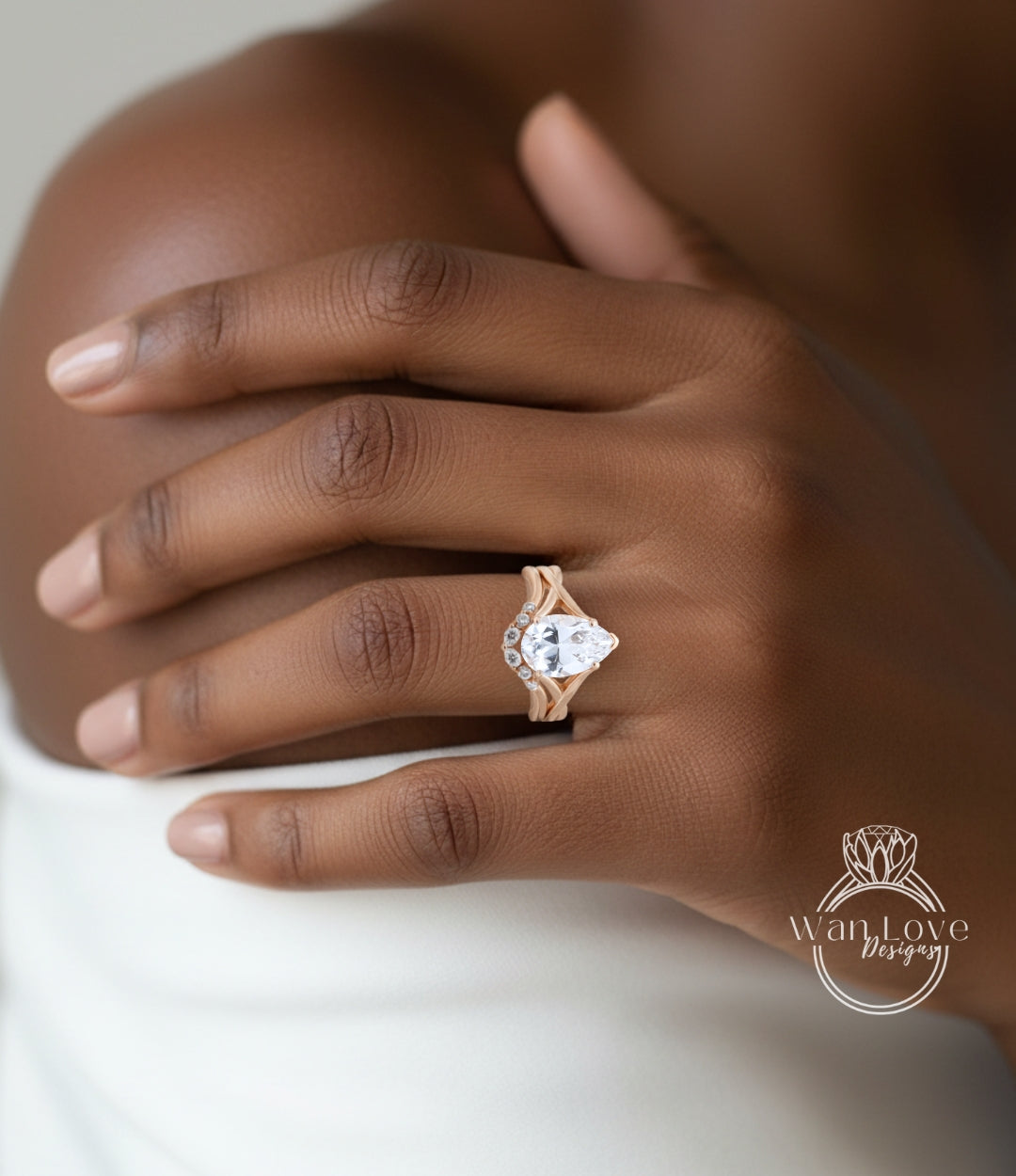 A close-up of a person's hand wearing a gold ring with a large diamond, resting on a white surface.