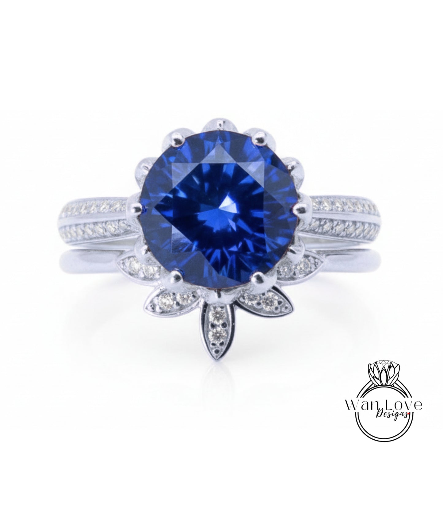 A stunning blue gemstone ring with a large central diamond surrounded by smaller diamonds, set in a silver band with a leaf-shaped accent.