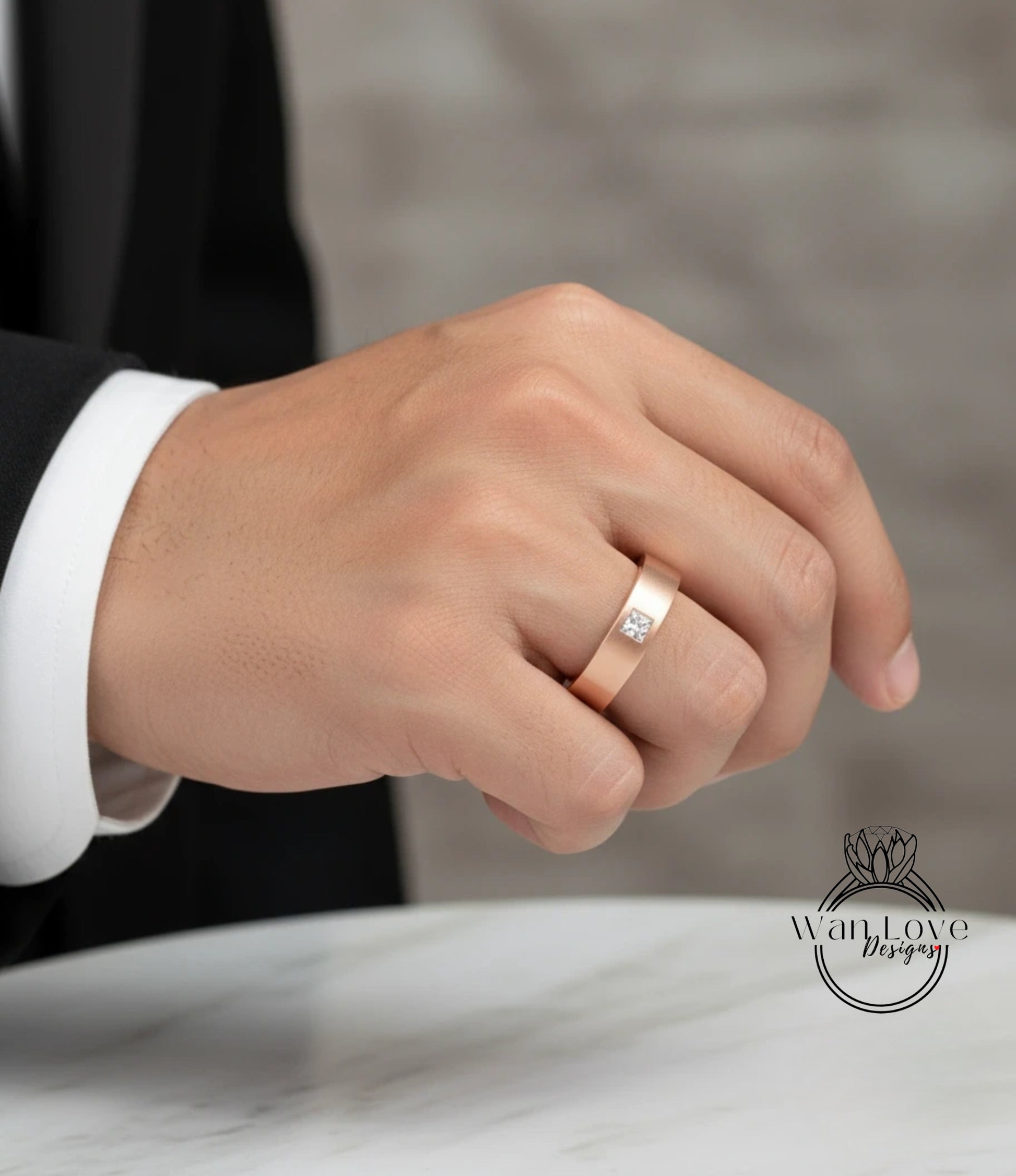 A close-up of a person's hand wearing a gold ring with a diamond.