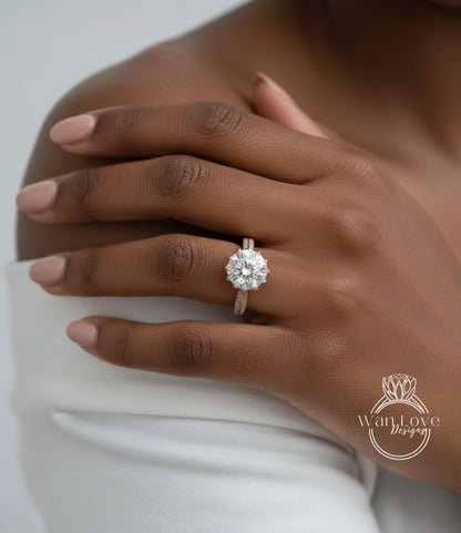 A close-up of a person's hand wearing a large, sparkling diamond engagement ring on the ring finger.