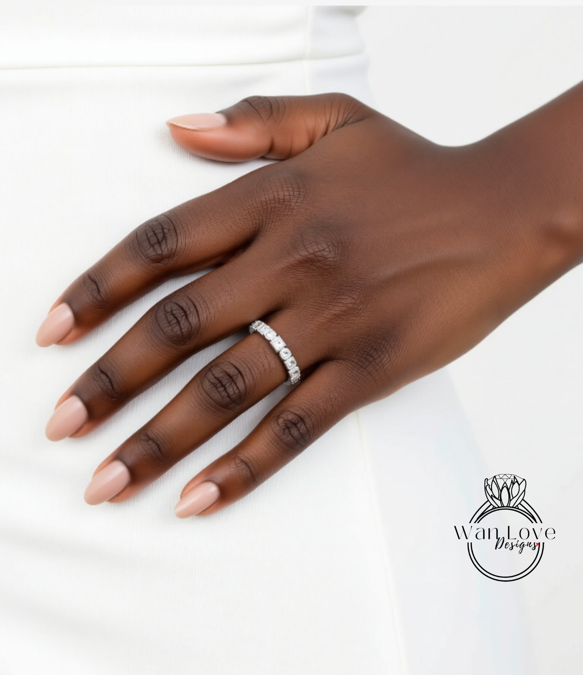 A close-up of a hand wearing a diamond ring on the ring finger.