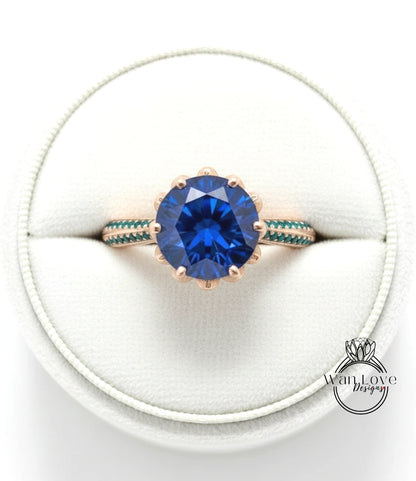 A close-up view of a gold ring with a large blue gemstone, placed in a white jewelry box.