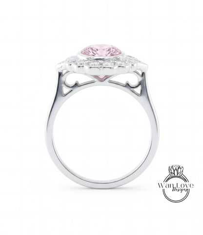 A silver ring with a large pink gemstone, possibly a diamond, set in the center.