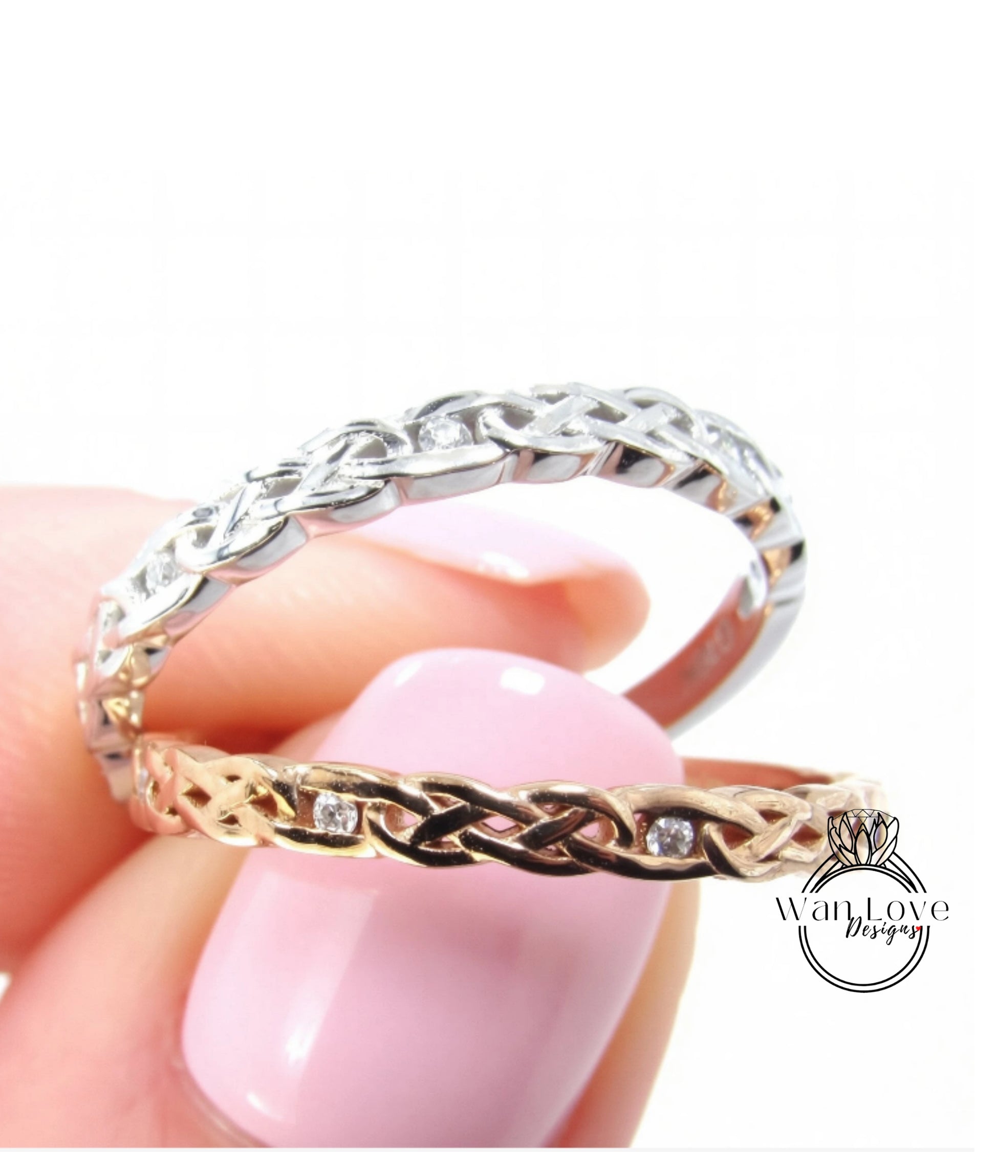 A close-up image of a person's hand holding two rings, one silver and one gold, with intricate designs.
