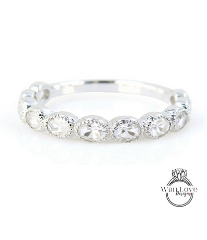 A silver ring with a row of round diamonds set in a band.