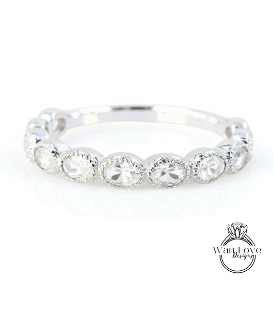 A silver ring with a row of round diamonds set in a band.