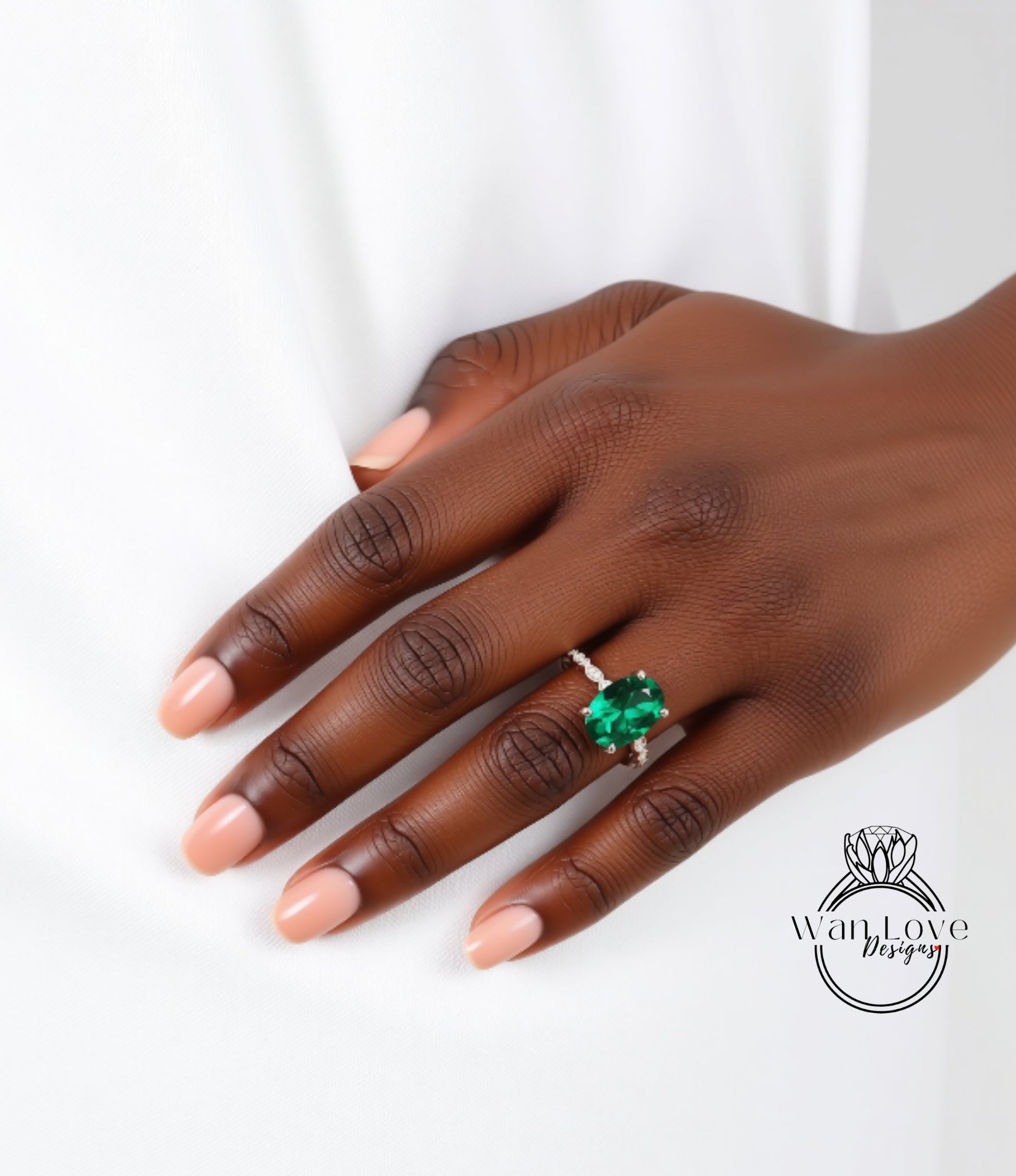A close-up of a hand wearing a ring with a large green gemstone.