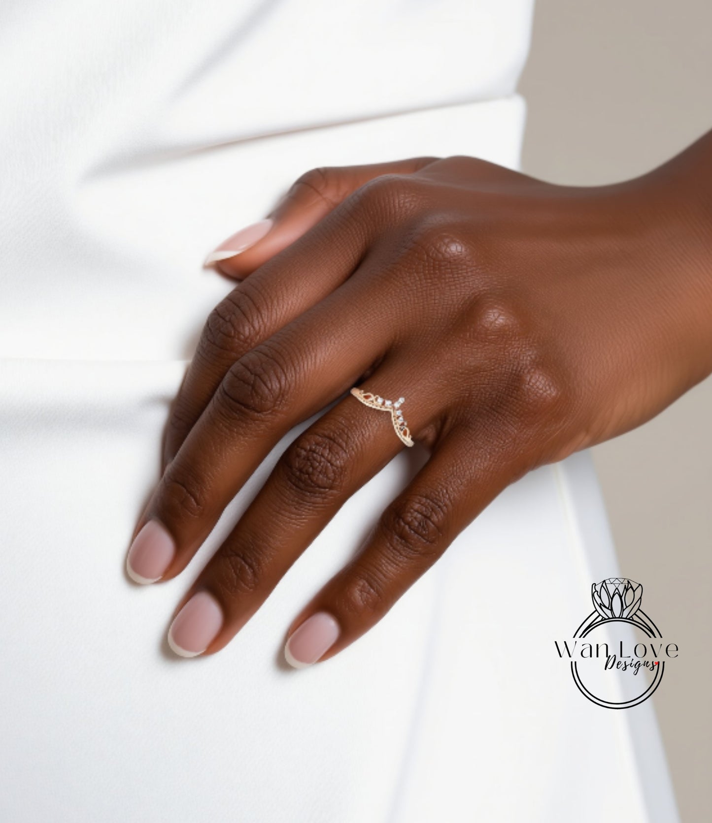 A close-up of a hand wearing a gold ring with a floral design.