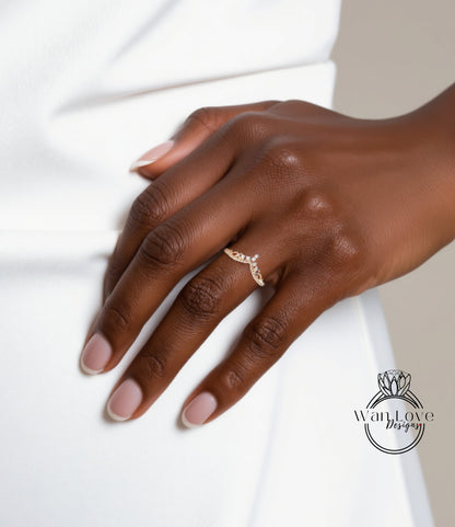 A close-up of a hand wearing a gold ring with a floral design.