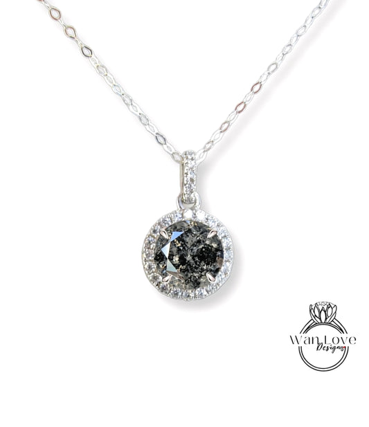 A silver necklace with a large, round diamond pendant.