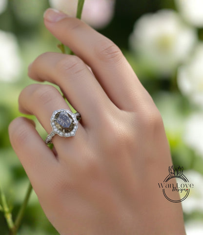 A close-up of a hand wearing a diamond ring with a large oval-shaped gemstone.