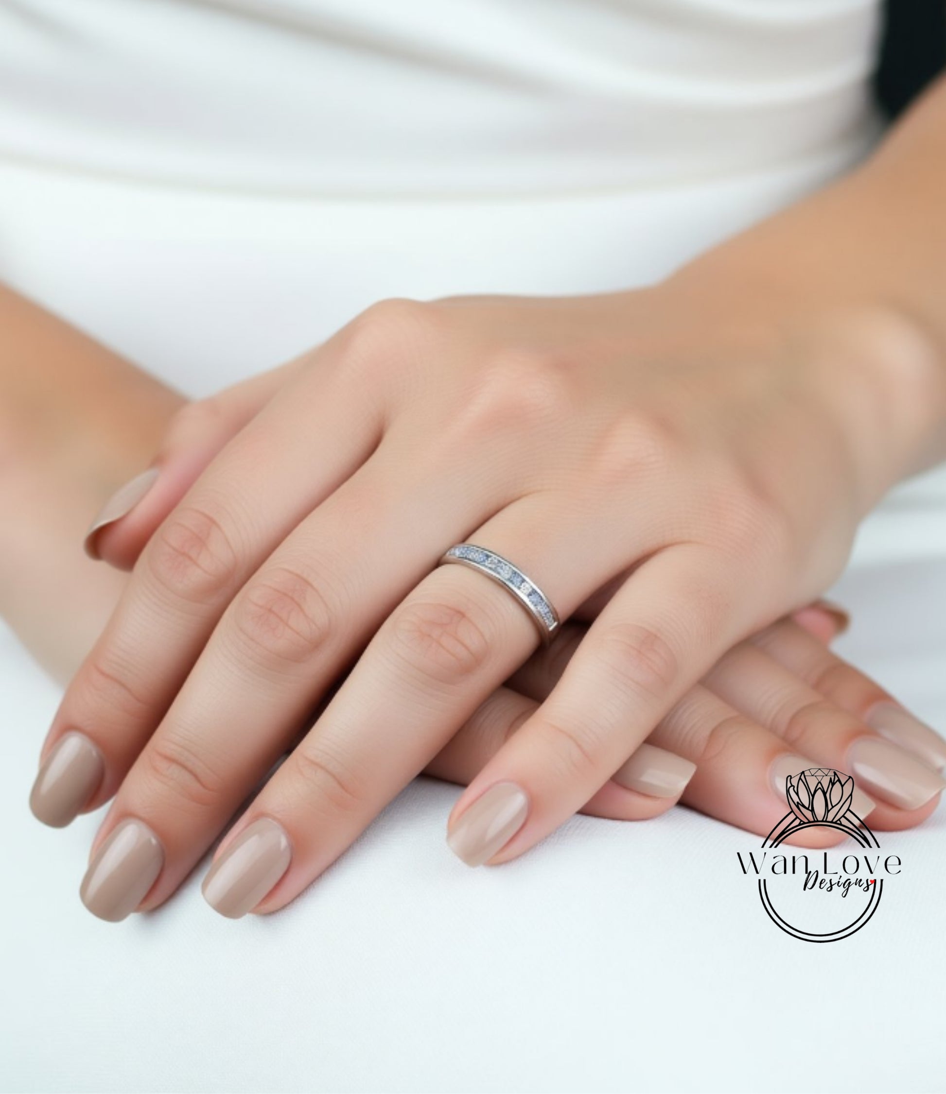 A close-up image of a person's hand wearing a ring, with their fingers crossed.