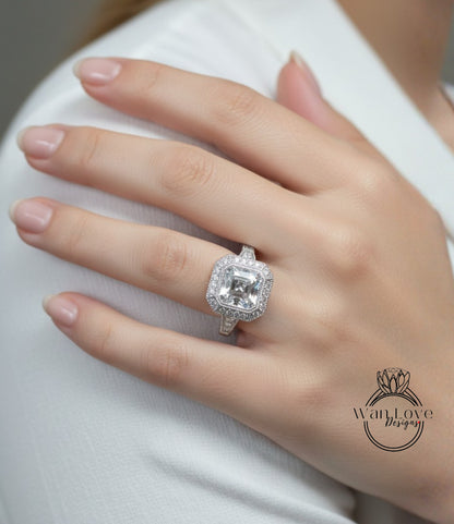 A close-up of a person's hand wearing a large, sparkling diamond ring on the ring finger.