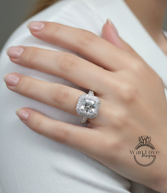 A close-up of a person's hand wearing a large, sparkling diamond ring on the ring finger.