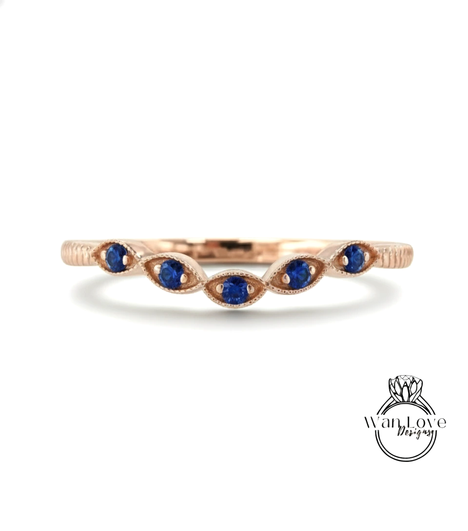 A rose gold ring with a row of blue sapphire stones set in the center.